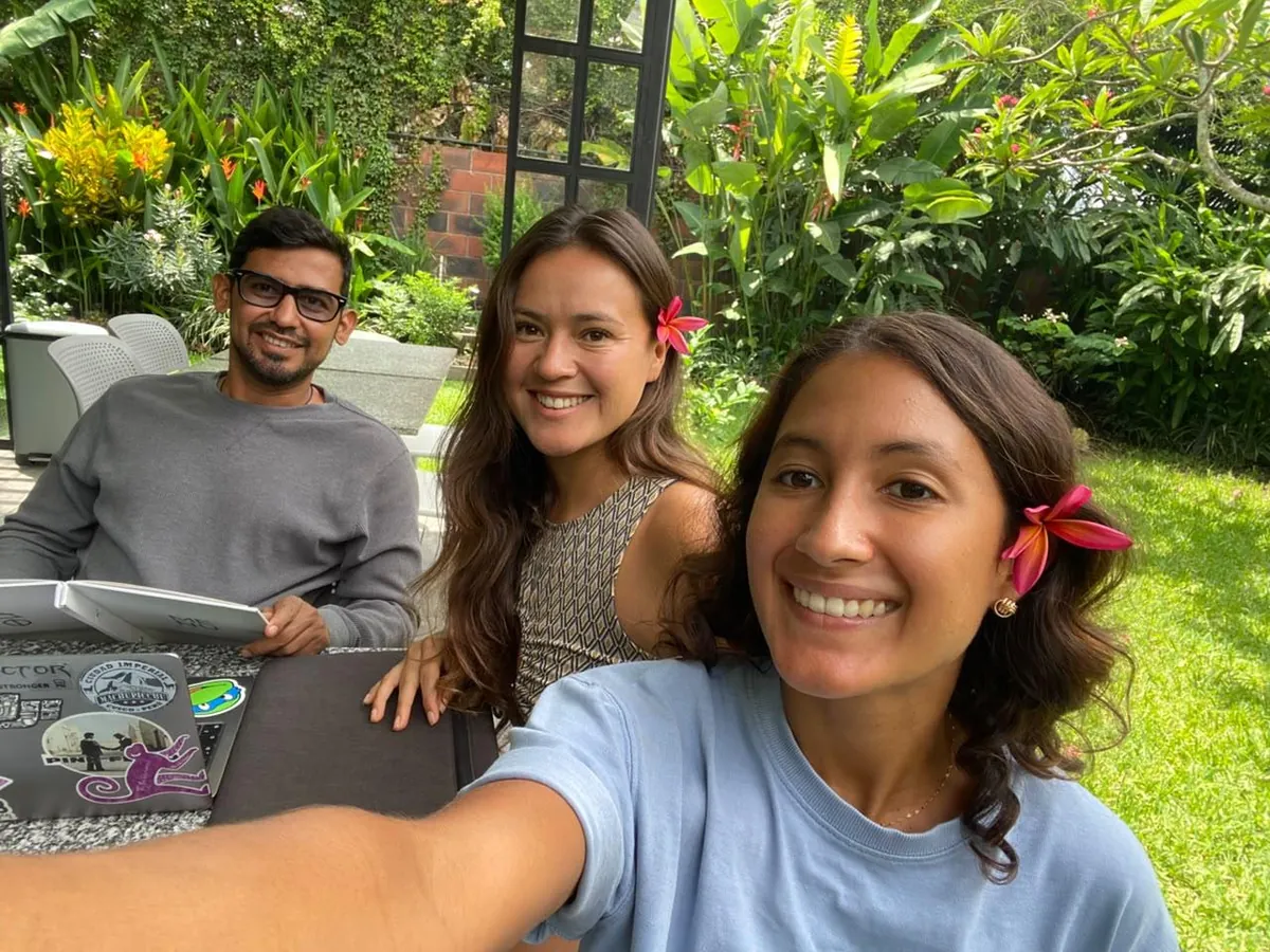 The Alegria Trips founders Rousse, Kaleb and Melissa smiling together in a garden