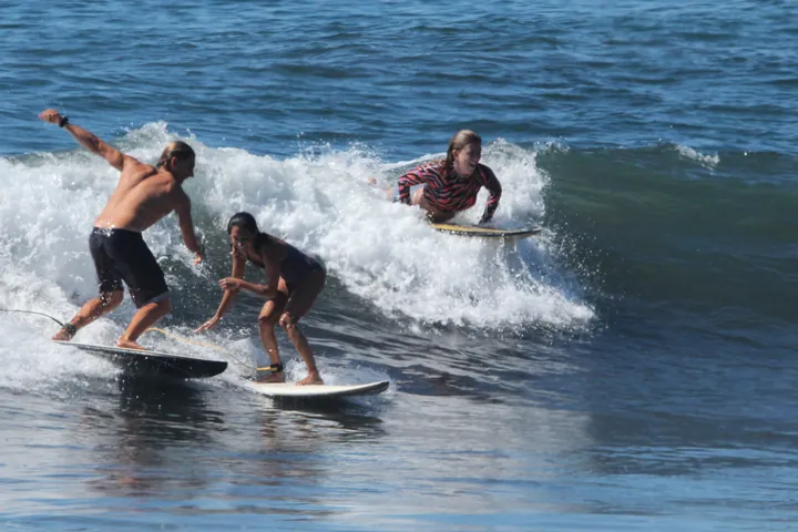 A local surfer coaching a guest on a wave at Mizata